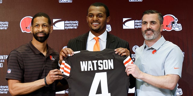 Cleveland Browns genel müdürü Andrew Berry, solda, yeni oyun kurucu Deshaun Watson, merkez ve baş antrenör Kevin Stefansky, 25 Mart 2022 Cuma günü Berea, Ohio'daki NFL futbol takımı eğitim tesisinde düzenlediği basın toplantısında bir fotoğraf için poz veriyor. 