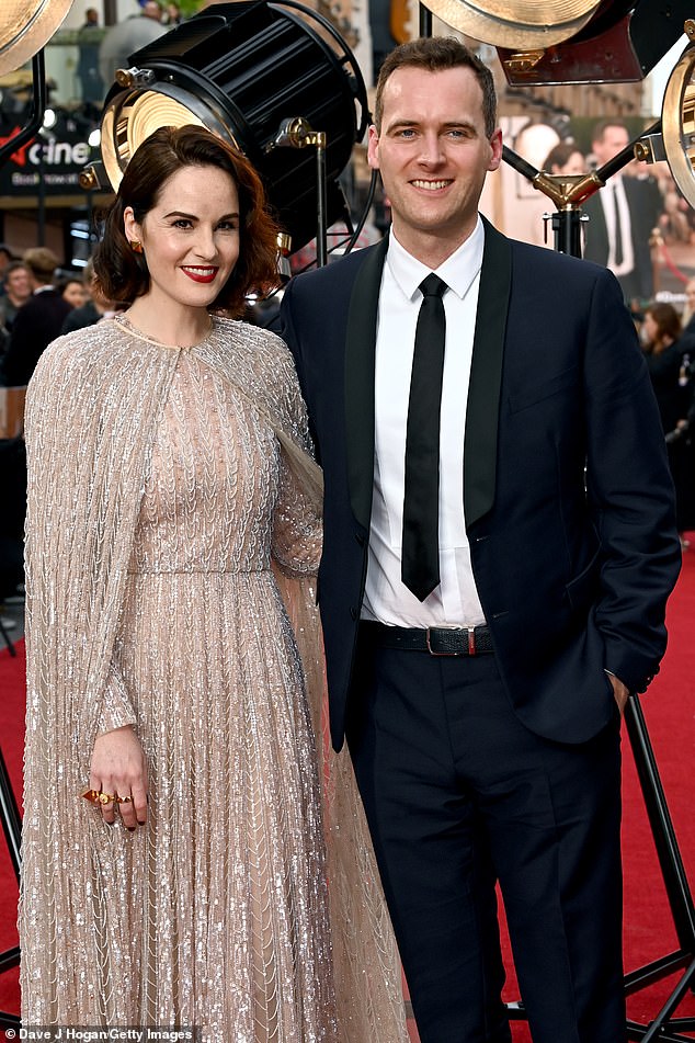Heyecan verici: Michelle, nişanlı bir çift olarak kırmızı halıda ilk çıkışını yaparken, Downton Abbey: New Era London'ın galasında göz alıcı gümüş bir elbiseyle parladı.