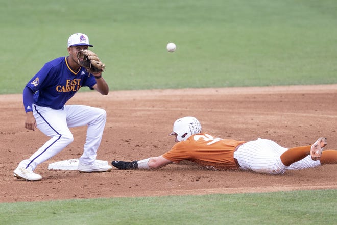 Teksaslı Eric Kennedy, 11 Haziran 2022'de Greenville, Kuzey Carolina'da bir beyzbol maçı sırasında Doğu Carolina oyuncusu Jacob Starling'in bayrağının altına girdi.
