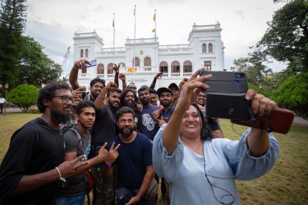 Protestocular, Başbakanlık Ofisini hükümet yetkililerine teslim ederken grup selfiesi için poz veriyor.