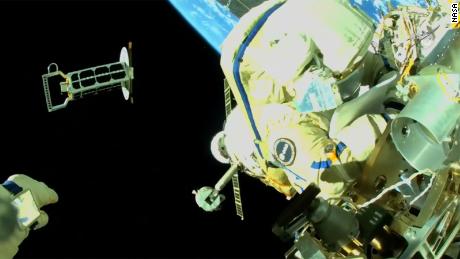 Cristoforetti, Uluslararası Uzay İstasyonunun dış cephesinde çalışırken, eli sol altta gösterilen Artemyev'in yörüngeye bir nano uydu fırlattığı görülüyor. 