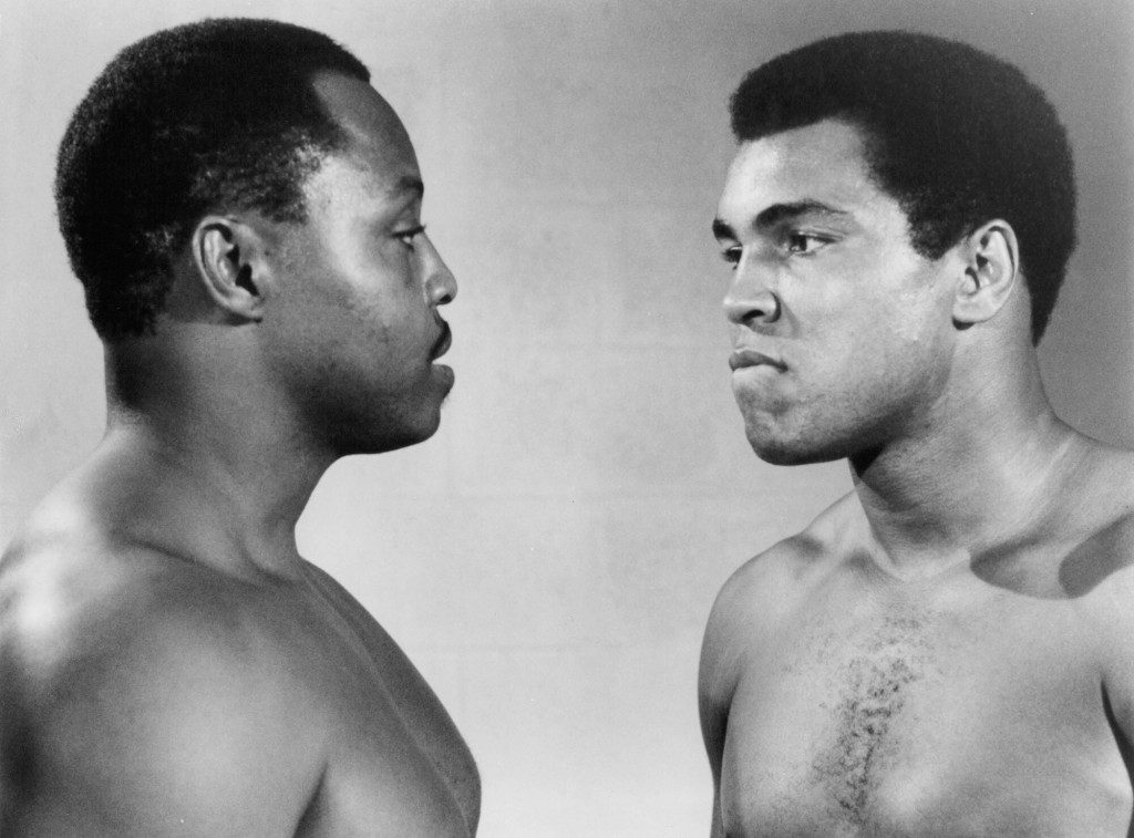 Filmden bir sahnede Roger E. Mosley ve Muhammed Ali yüz yüze duruyor "En büyük" 1977'de. 
