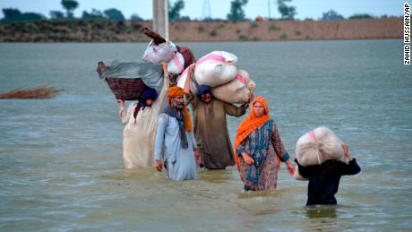 Yerinden edilmiş bir aile, 24 Ağustos'ta Pakistan'ın güneybatısındaki Belucistan eyaletinin bir bölgesi olan Caferabad'da sel basan bir bölgede yüzüyor.