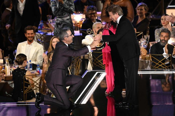 John Oliver En İyi Çeşit Konuşma Dizisi ödülünü alırken diz çöküyor.
