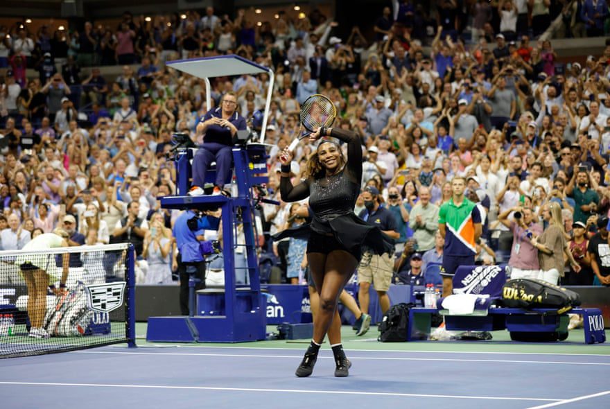Serena Williams, zaferinin ardından sahada dururken raketini ve kolunu kalabalığa doğru kaldırıyor