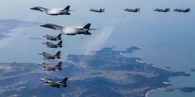 Güney Kore Savunma Bakanlığı tarafından sağlanan bu fotoğrafta, iki ABD Hava Kuvvetleri B-1B bombardıman uçağı uçuyor, orta üstte ve Güney Kore Hava Kuvvetleri F-35 ve ABD Hava Kuvvetleri F-16 savaş uçakları aşağıda. Solda, güneyin üzerinde Kore Yarımadası, 19 Kasım 2022 Cumartesi, Güney Kore'de ortak bir hava tatbikatı sırasında. 