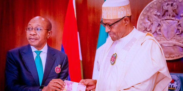 DOSYA: Nijerya Devlet Başkanı Muhammadu Buhari'nin 23 Kasım 2022'de kalpazanlık ve artan güvenlik sorunları nedeniyle yeni tasarlanan banknotları açıklamasının ardından Nijerya Merkez Bankası (CBN) Başkanı Godwin Emifiel, solda, yeni banknotların sunumuna katılıyor , Abuja, Nijerya'da.