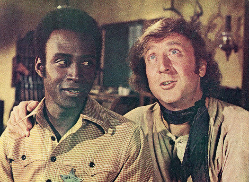 Filmden bir karede Gene Wilder (sağda) kolunu Cleavon Little'ın omzuna atıyor. "yanan eyer," Mel Brooks'un yönettiği, 1974.